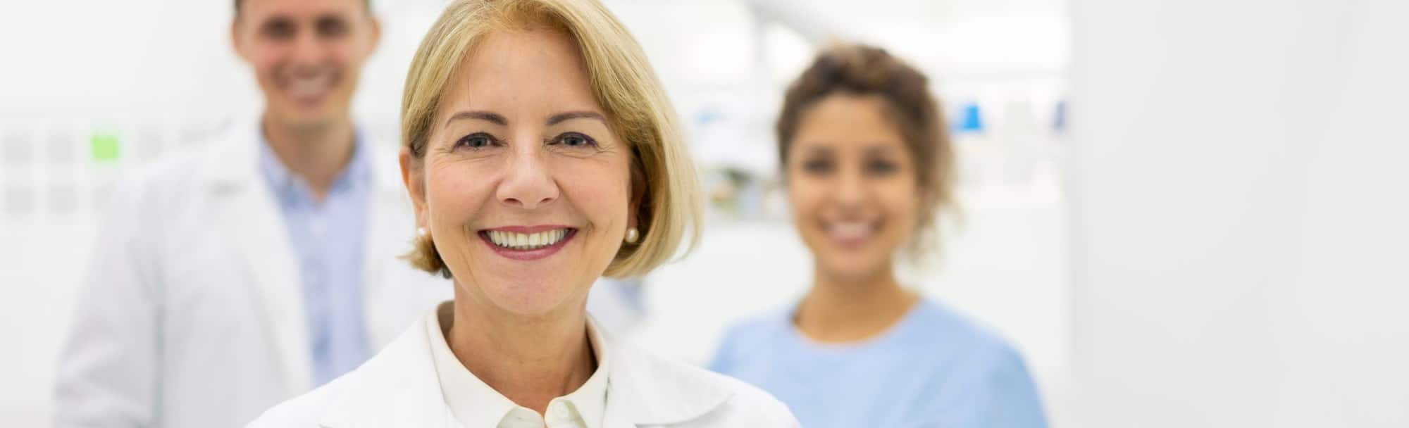 close-up of a female doctor standing in front of two medical assistants