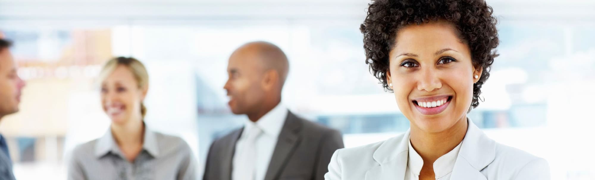 smiling woman standing in front of three celebrating coworkers