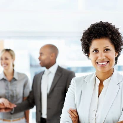 smiling woman standing in front of three celebrating coworkers