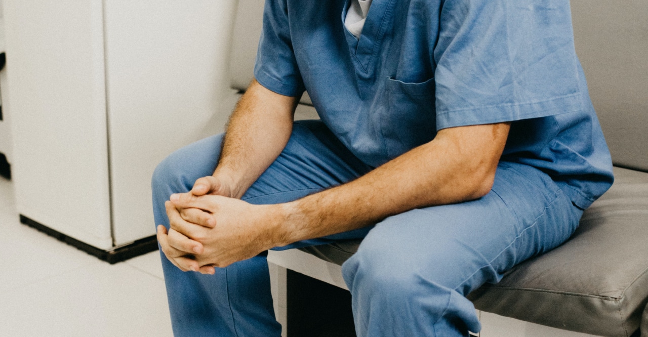 Man in scrubs holding hands