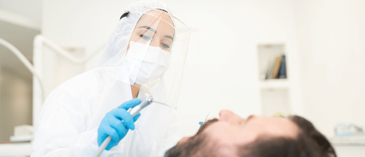 Dentist leaning over patient with mouth open