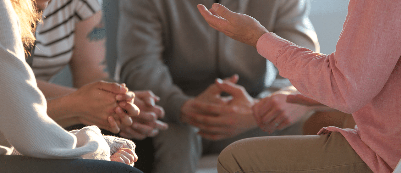 Group of people sitting in circle talking