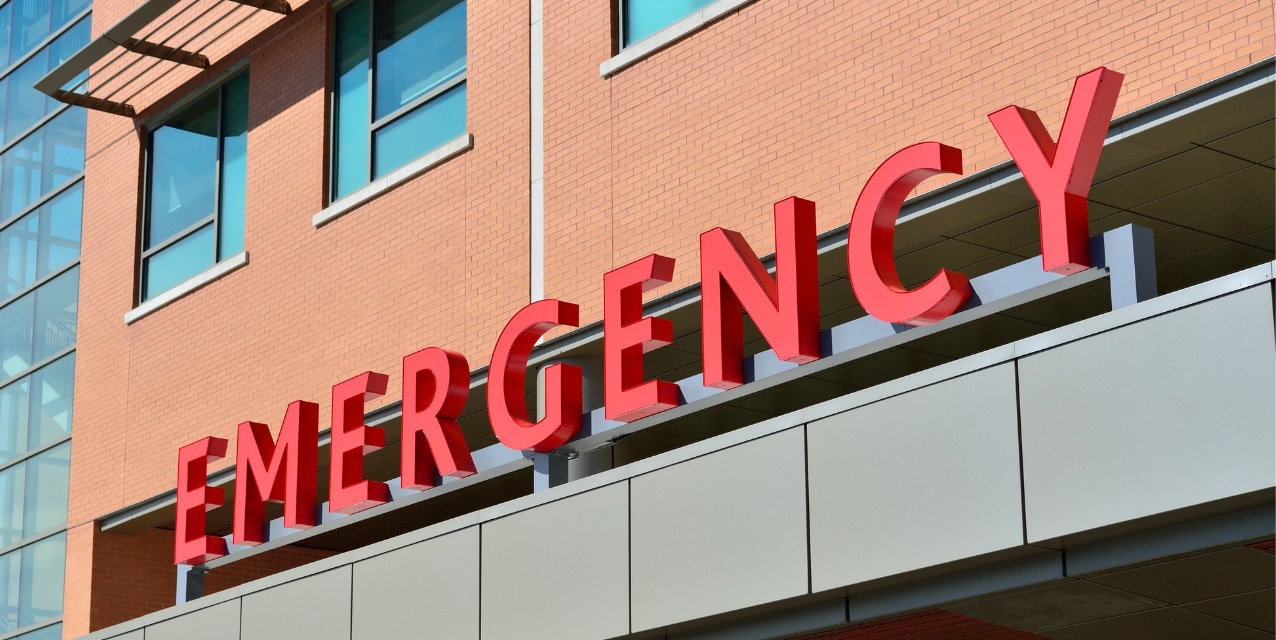 Close-up of exterior signage on the roof of a hospital entrance that reads Emergency.
